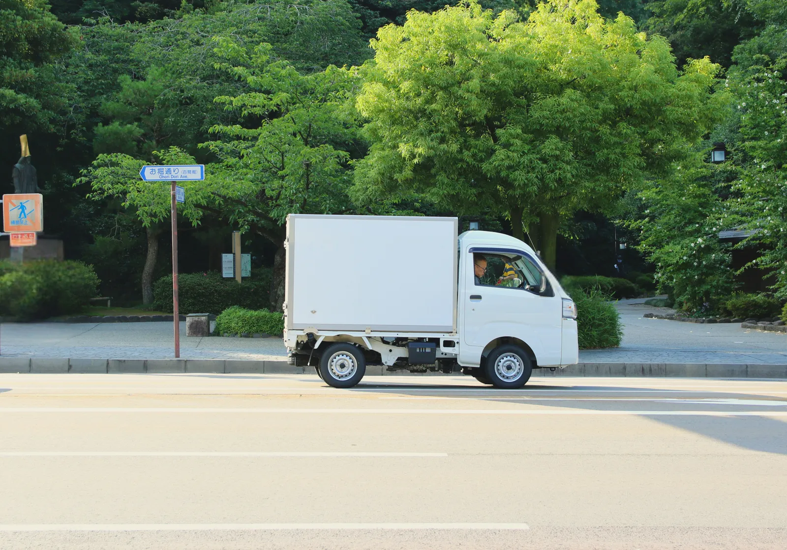 A small white delivery truck on an urban street.