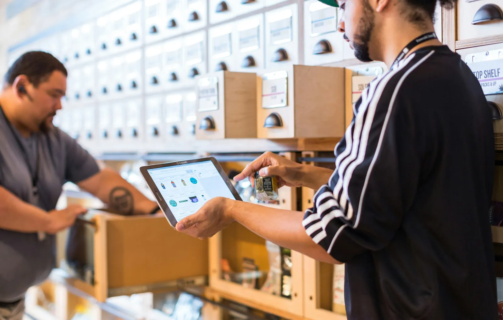 A warehouse worker using a tablet while checking inventory.