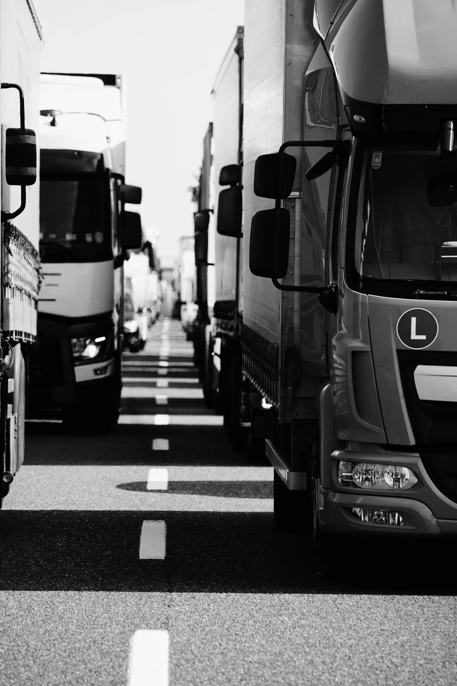 Rows of parked freight trucks in a black-and-white photograph.